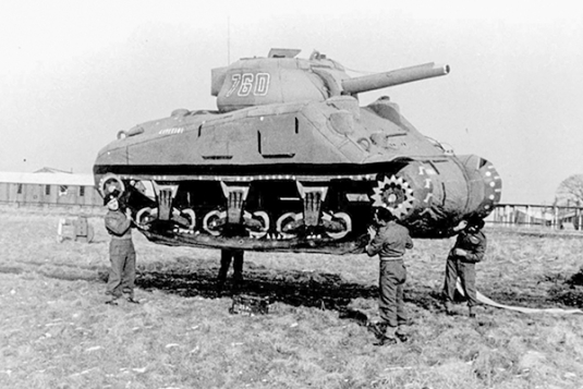 Soldiers carry a rubber tank (decoy) during the 23rd’s buildup for World War II.