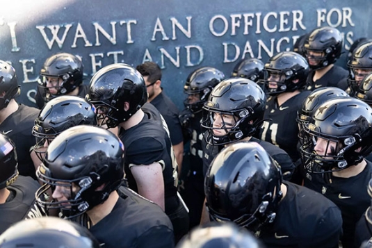 West Point Football Team with Plague on Wall